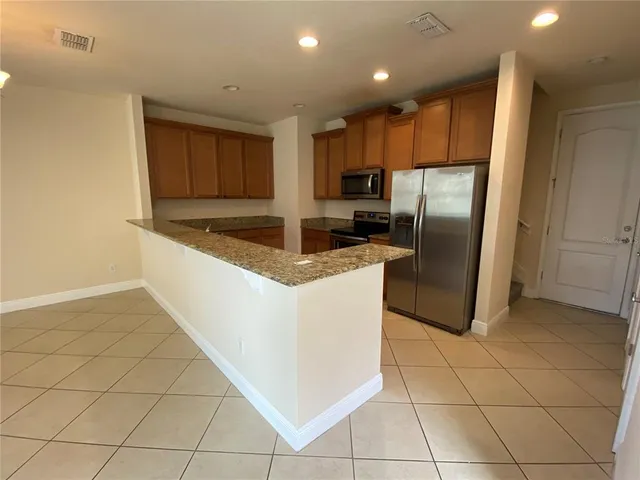 a kitchen with stainless steel appliances granite countertop a refrigerator and a sink
