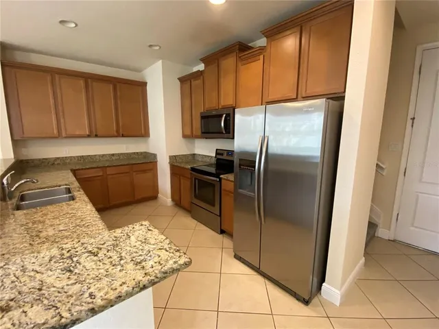 a kitchen with stainless steel appliances granite countertop a refrigerator and a sink