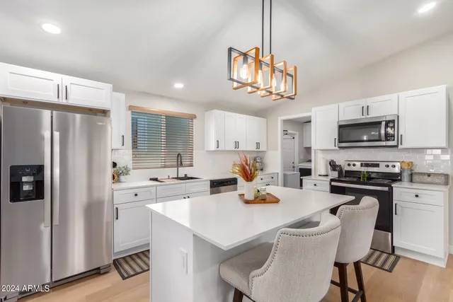 a kitchen with a table chairs refrigerator and microwave