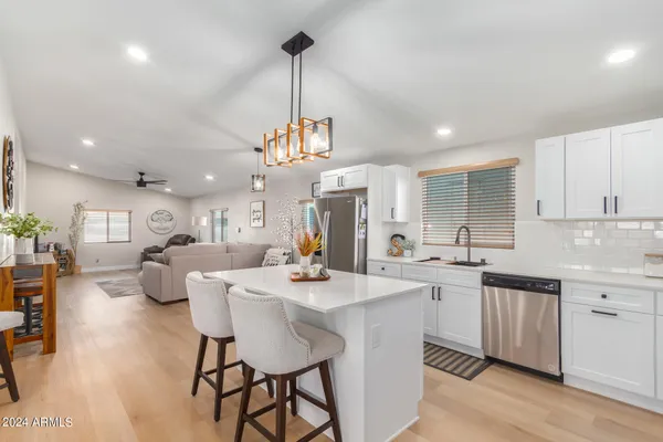 a large kitchen with a counter space a sink appliances and cabinets