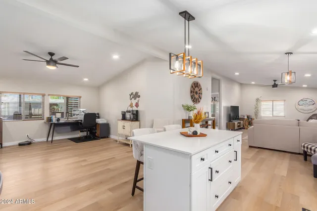 a view of a dining room and livingroom with furniture wooden floor a chandelier