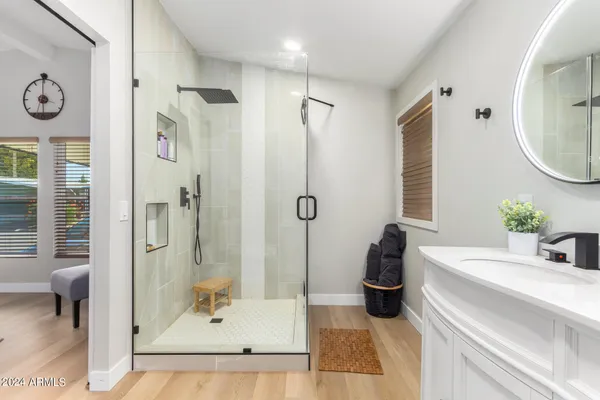 a bathroom with a tub a sink and a mirror