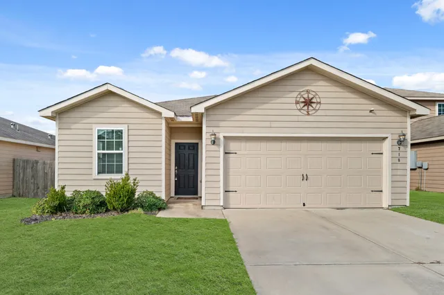 a view of a house with a yard and garage
