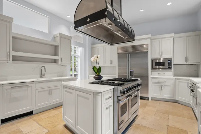a kitchen with stainless steel appliances a stove a sink and a refrigerator
