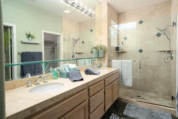 a bathroom with a double vanity sink mirror and shower
