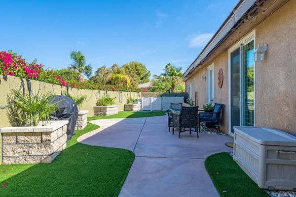 a view of a patio with a table chairs and a garden