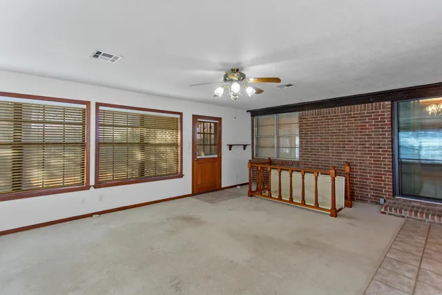 a view of an empty room with a fireplace and a window
