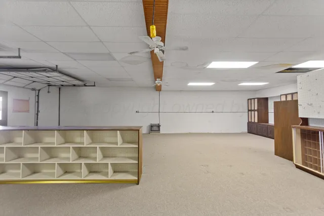 a living room with furniture and a refrigerator