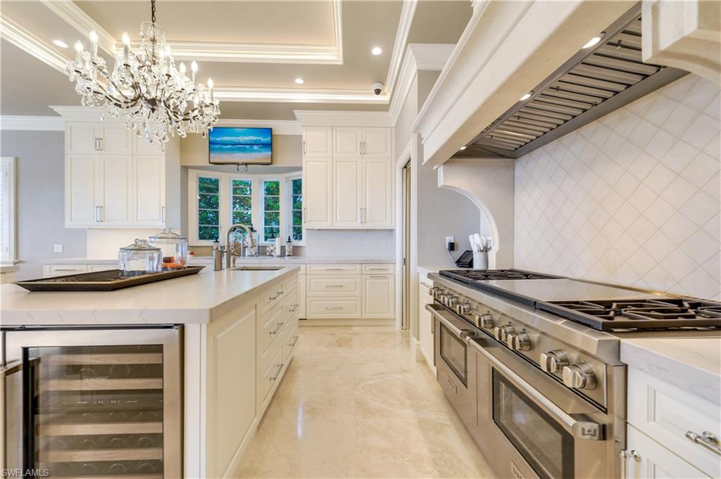 2300 Kingfish Road Naples, FL 34102 - Photo 12 of 36 a kitchen with stainless steel appliances granite countertop a stove and a chandelier
