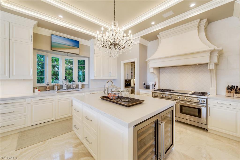 2300 Kingfish Road Naples, FL 34102 - Photo 13 of 36 a kitchen with a stove a sink a chandelier and living room view
