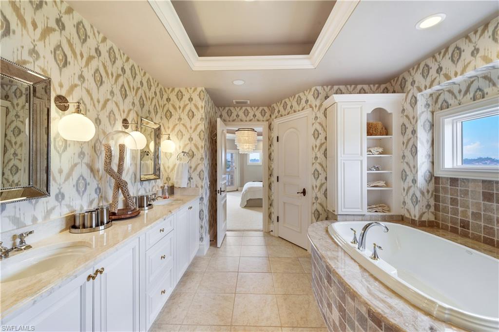 2300 Kingfish Road Naples, FL 34102 - Photo 19 of 36 a large spacious bathroom with a granite countertop tub sink a mirror a shower and a bathtub