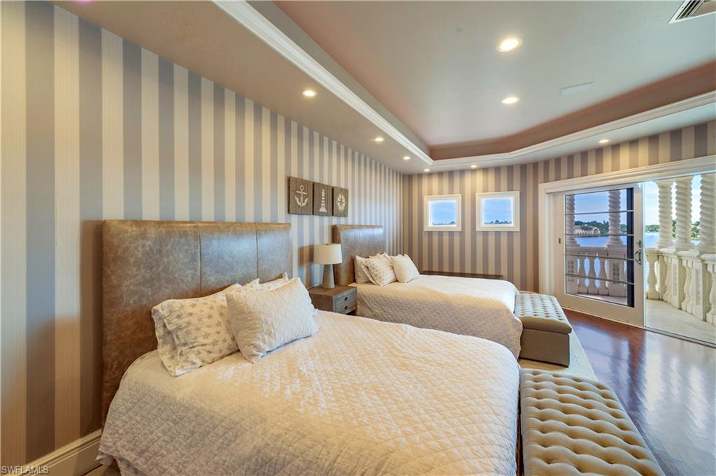 2300 Kingfish Road Naples, FL 34102 - Photo 27 of 36 a large bedroom with bed and wooden floor