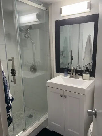 a bathroom with a sink a toilet and shower