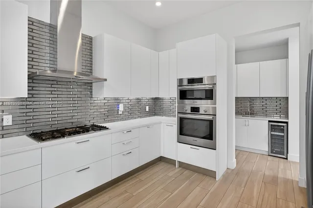 a kitchen with granite countertop white cabinets and stainless steel appliances