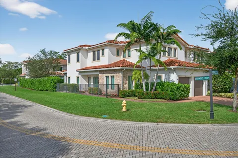 a front view of a house with a yard and potted plants