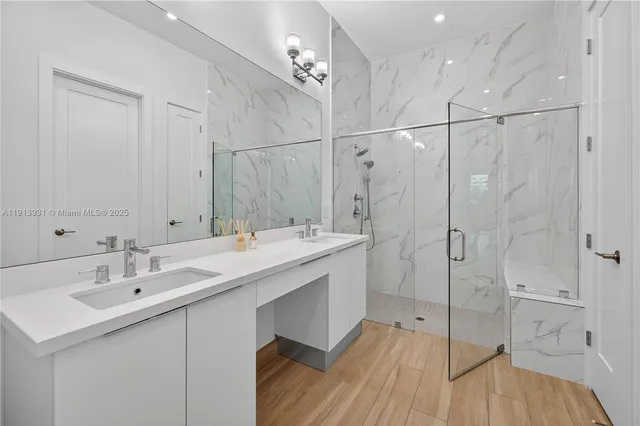 a bathroom with a sink shower and a mirror