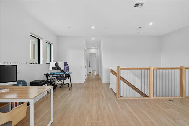 a view of a workspace with furniture and wooden floor