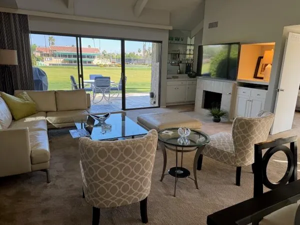 a living room with fireplace furniture and a floor to ceiling window