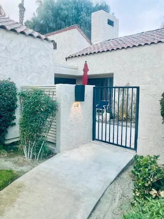 a view of a house with a big yard and potted plants