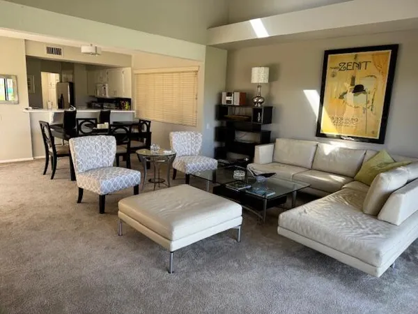 a living room with couches and a potted plant on table