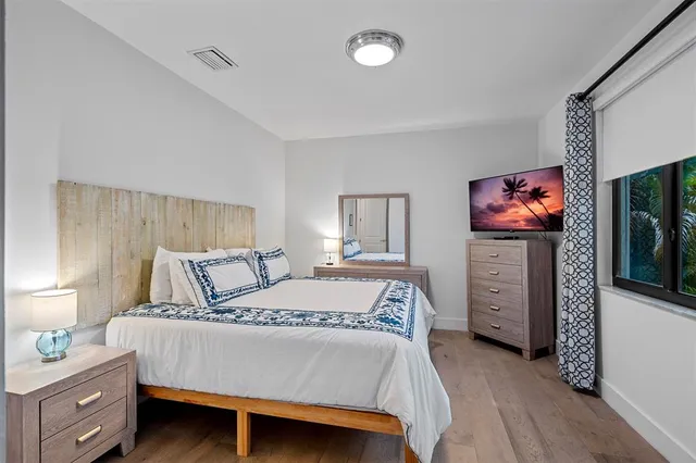 a bedroom with a bed and a flat screen tv