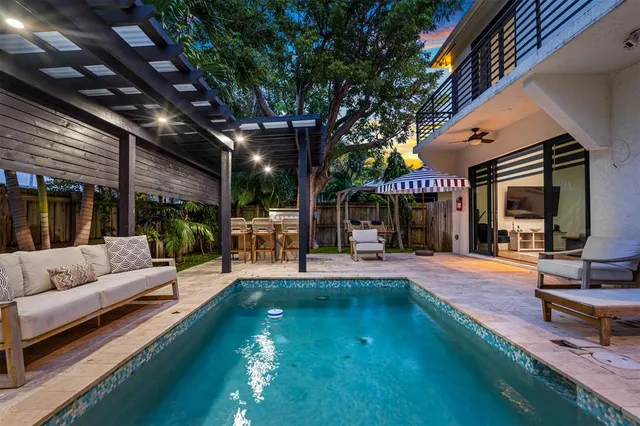 a living room with patio furniture and a large tree