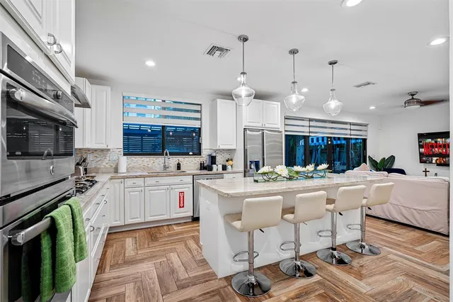 a large kitchen with kitchen island a sink a stove a center island and a stove