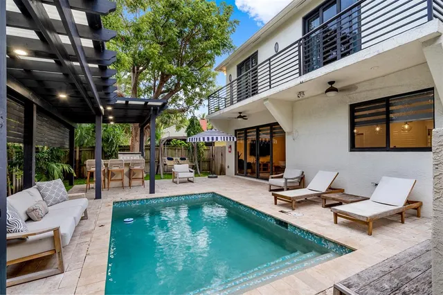 a view of a patio with couches table and chairs with wooden floor and fence
