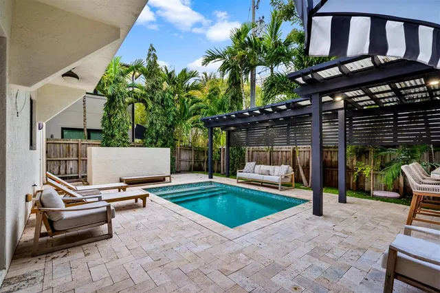 a swimming pool with outdoor seating and yard