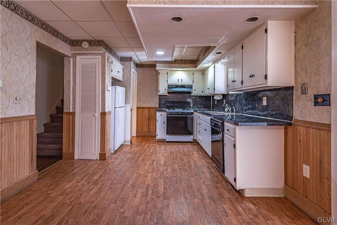 1177 Arcadia Street Bethlehem, PA 18018 - Photo 10 of 32 a kitchen with stainless steel appliances granite countertop a refrigerator a sink dishwasher a stove and white countertops with wooden floor