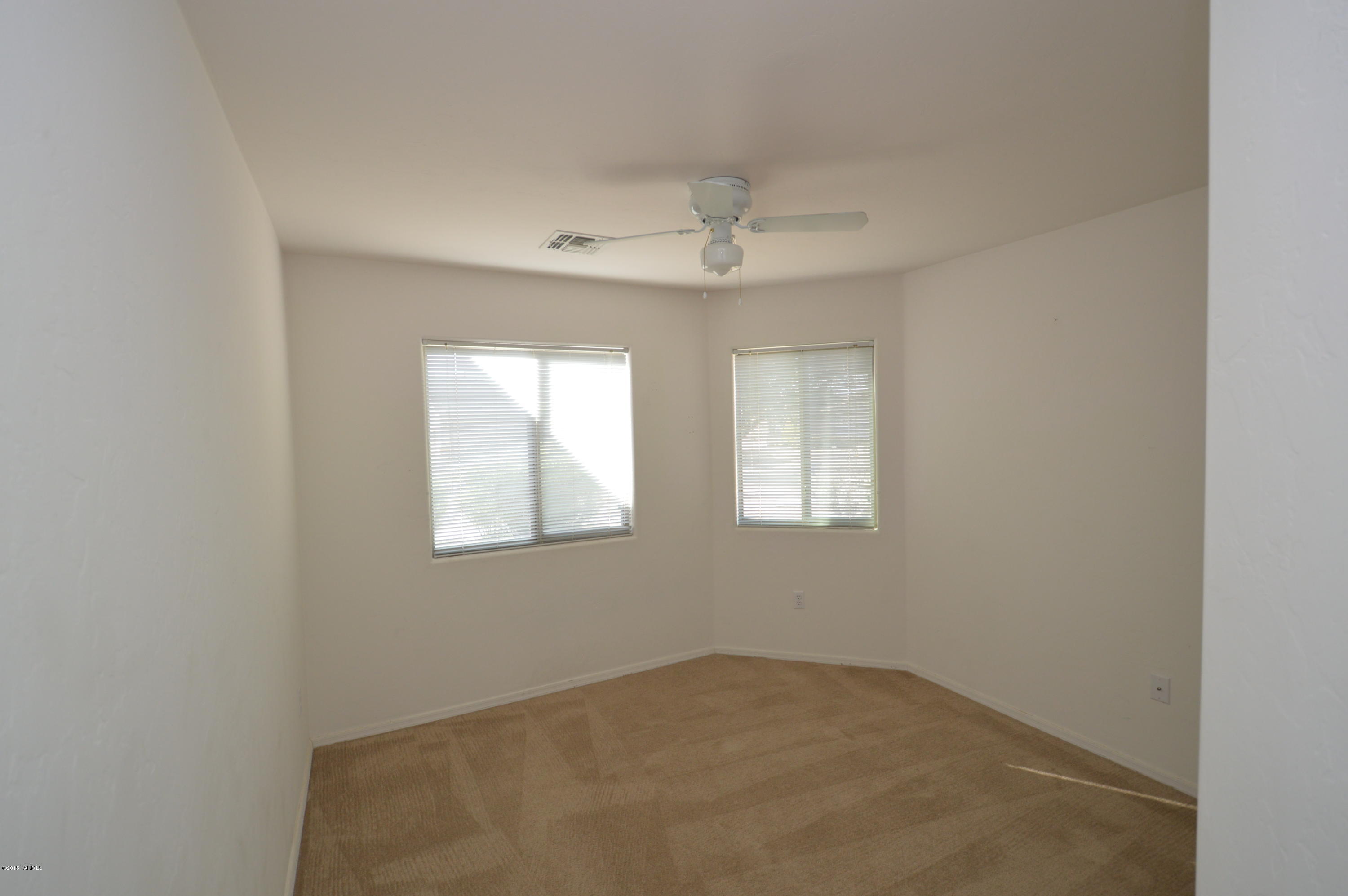 8396 West Benidorm Loop Tucson, AZ 85757 - Photo 8 of 13 an empty room with windows and fan