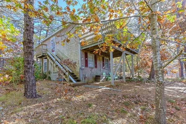 a view of a house with a yard and wooden fence