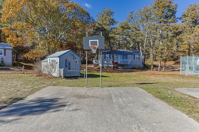 a view of a house next to a yard and large trees