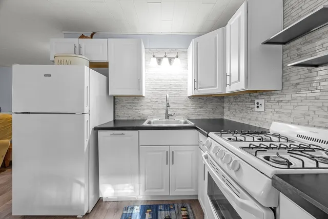a kitchen with a white cabinets stove and refrigerator