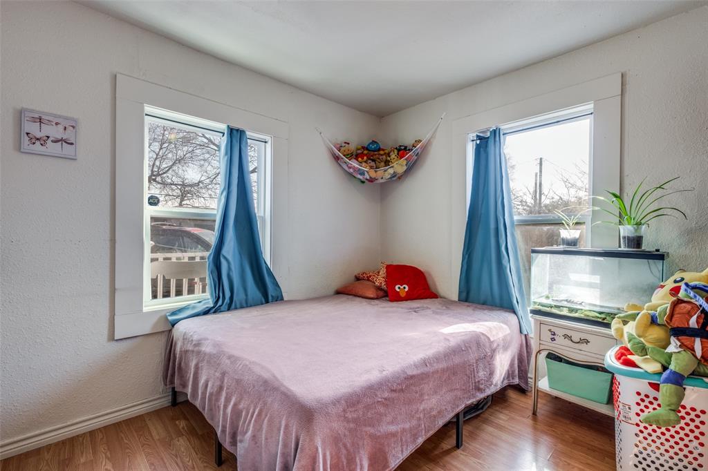 4755 Yancy Street Dallas, TX 75216 - Photo 8 of 12 a bedroom with a bed and wooden floor