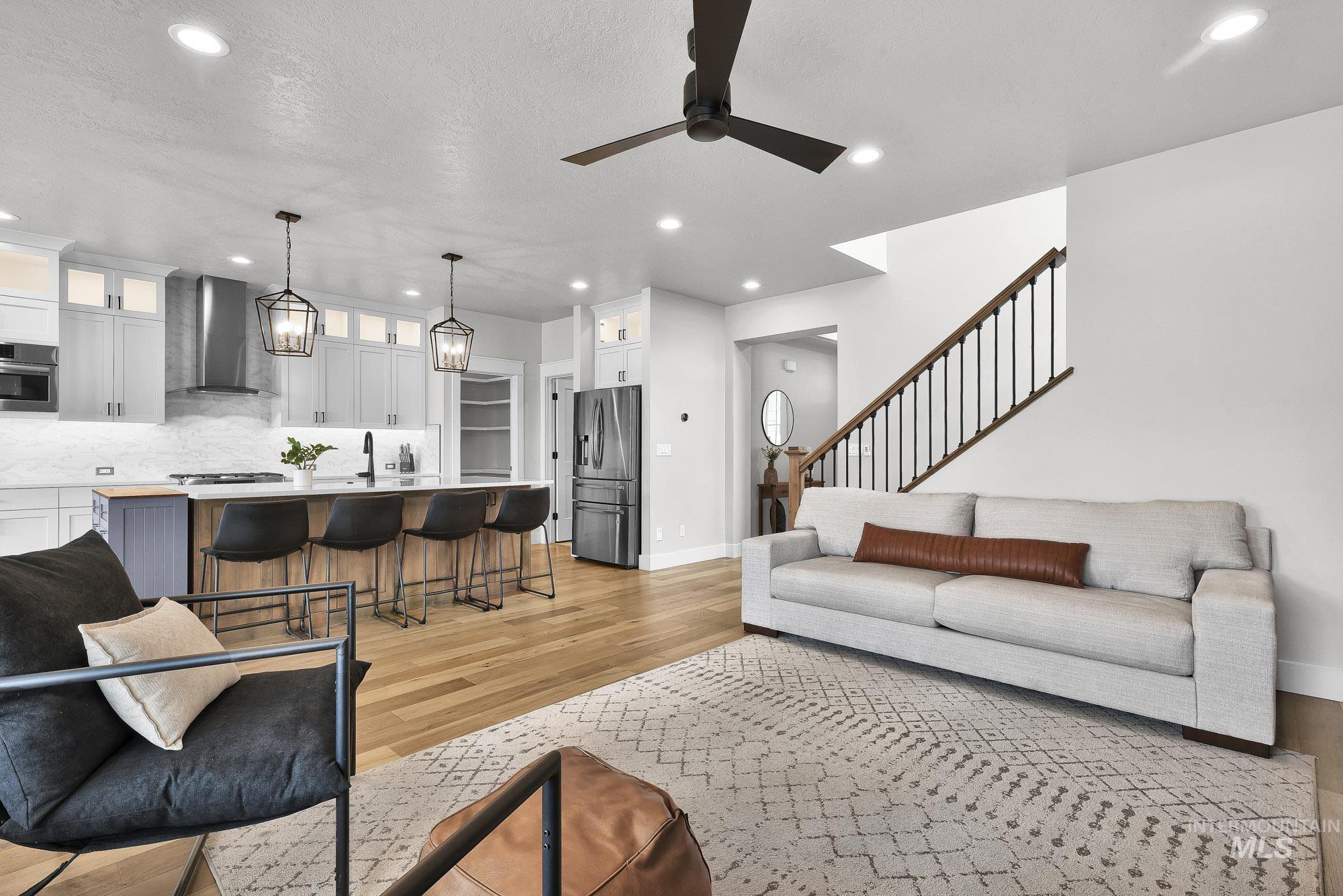 5676 East Zaffre Ridge Street Boise, ID 83716 - Photo 22 of 50 Open-concept living area featuring light wood-finish flooring, recessed lighting, and a dark ceiling fan