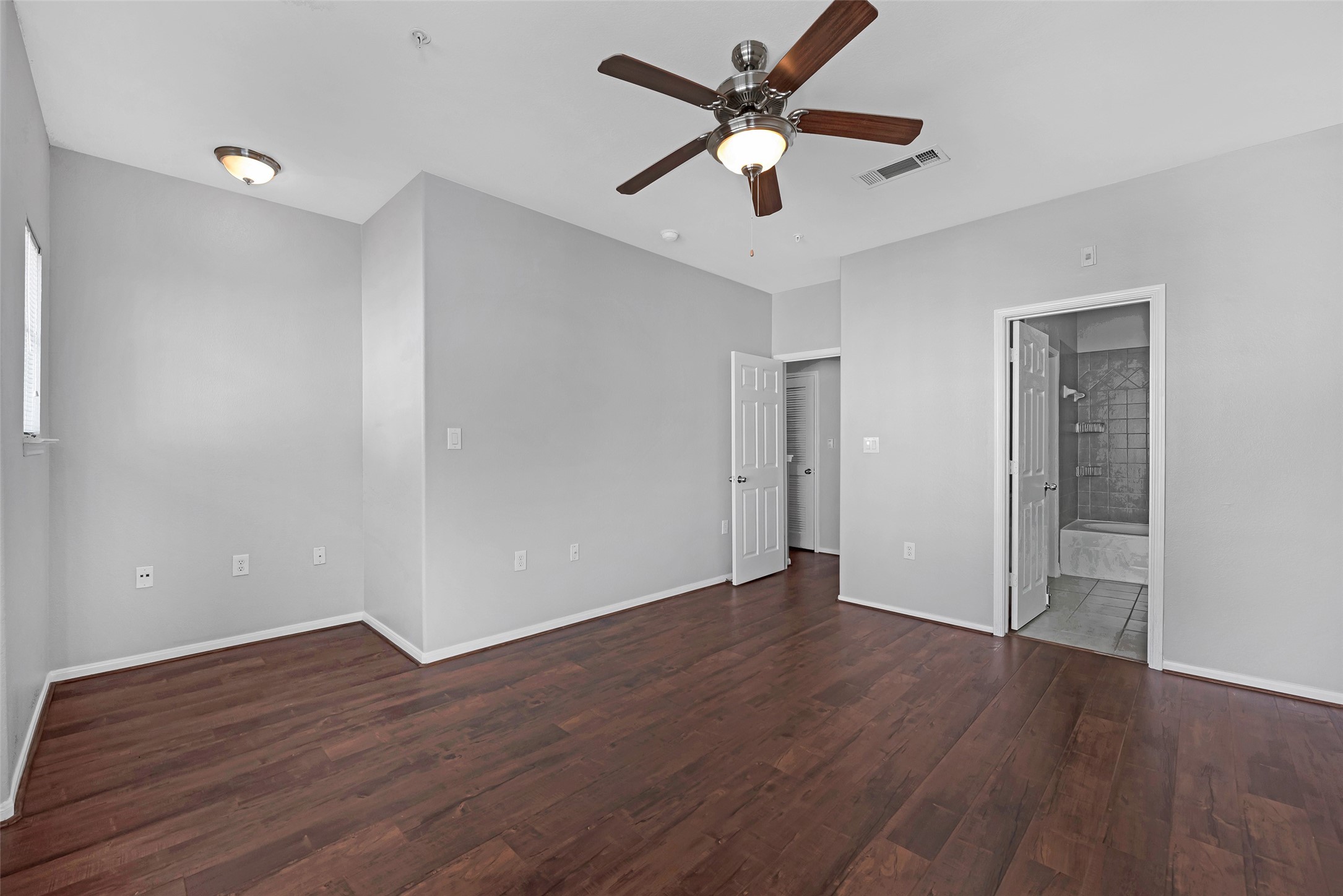 9200 Westheimer Road, Unit 1309 Houston, TX 77063 - Photo 6 of 28 an empty room with wooden floor and a ceiling fan