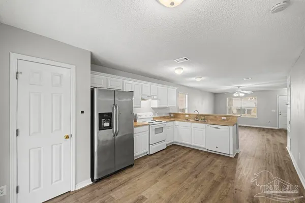 a kitchen with stainless steel appliances granite countertop a refrigerator and a stove top oven
