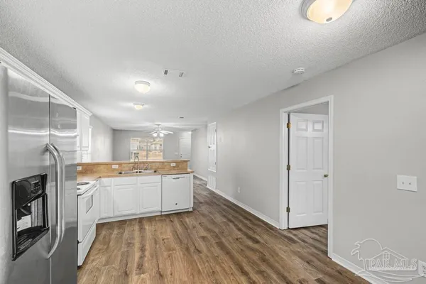 a kitchen with a sink a refrigerator and cabinets