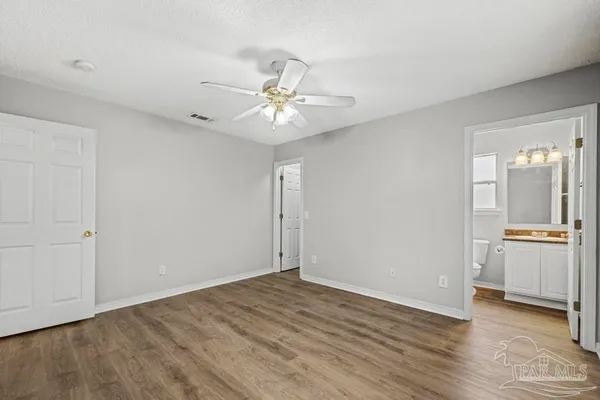an empty room with a bathroom and a ceiling fan