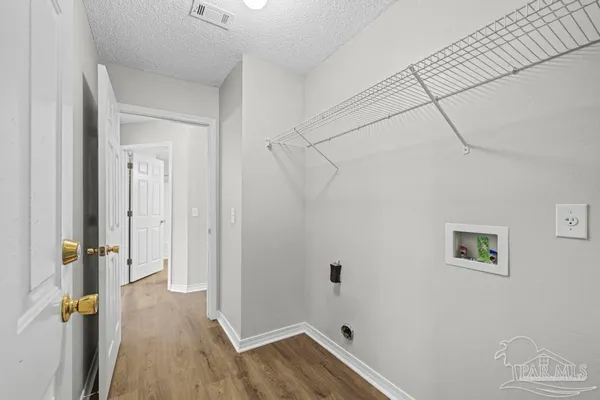 wooden floor in an empty room with a chandelier fan