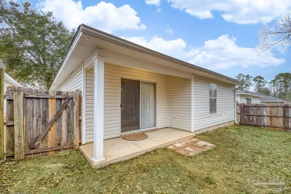 a view of a house with a yard and wooden fence