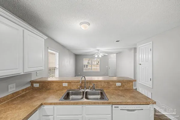 a kitchen with sink a window and cabinets