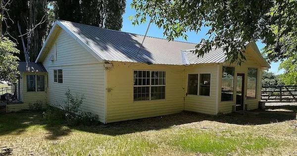 a view of house with backyard and trees