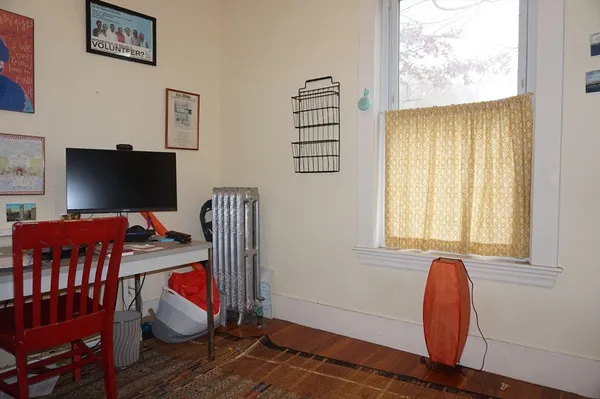 a view of a workspace with furniture and a window