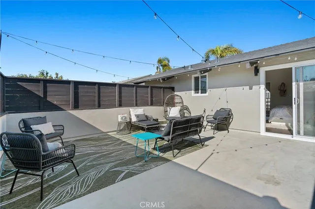 a roof deck with table and chairs and potted plants