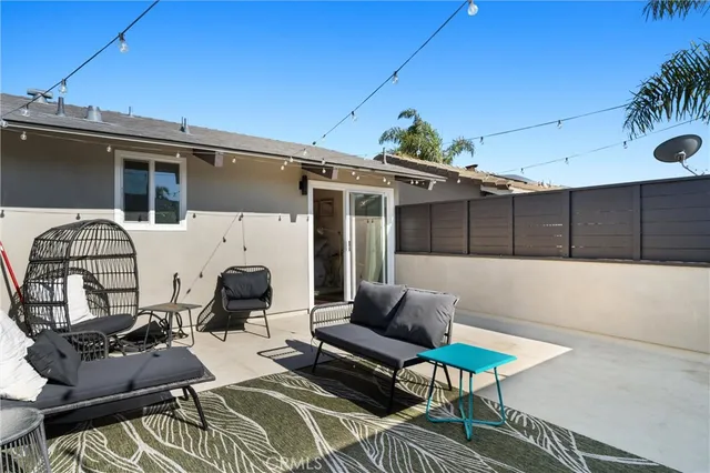 a view of a patio with couches table and chairs and potted plants