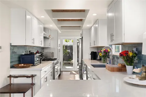 a kitchen with a sink a stove and cabinets