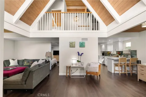 a living room with furniture and a dining table with wooden floor