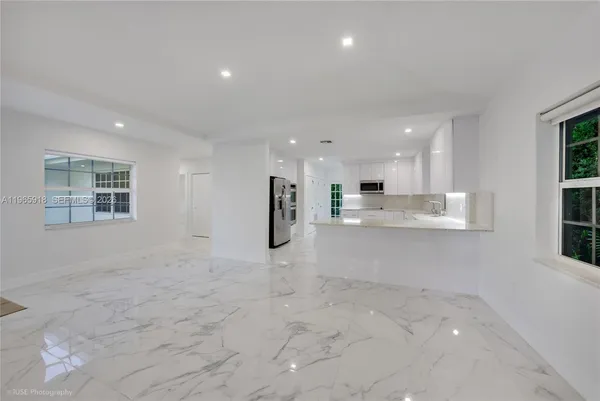 a view of kitchen with kitchen island white cabinets and refrigerator